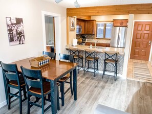 A modern kitchen with granite countertops, wooden cabinets, and a stainless steel refrigerator.
