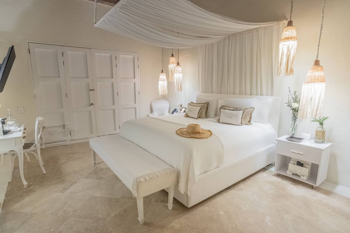 Ein Schlafzimmer mit einem Bett, Nachttischen, einem Schreibtisch und einem Stuhl.