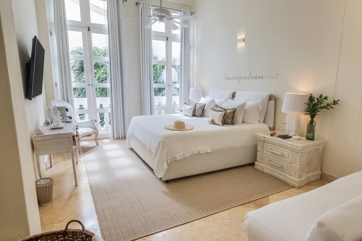 Ein Schlafzimmer mit Bett, Nachttisch, Lampe und einer Wand mit einem Schild.