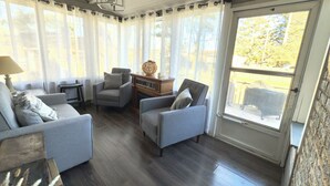 Una sala de estar acogedora con dos sillones grises, una mesa de centro de madera y una lámpara.