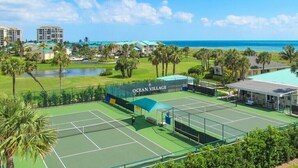 Un court de tennis avec un club adjacent portant l’inscription « Ocean Village ».
