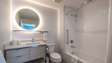 A modern bathroom with a toilet, sink, and shower.