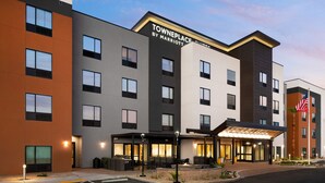 A multi-story hotel with a modern design, featuring a prominent entrance with a covered area and outdoor seating. - TownePlace Suites by Marriott Las Vegas North I-15 (Las Vegas)