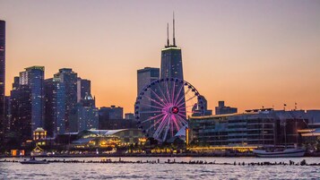 A waterfront cityscape with a prominent Ferris wheel and modern skyscrapers.