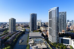Un hôtel de grande hauteur au design moderne, situé près d’une rivière et doté d’un quai pour bateaux.