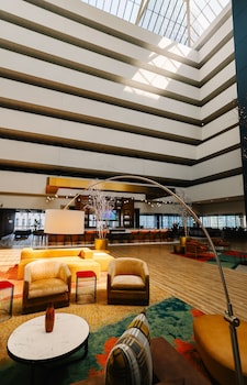 An indoor swimming pool with a high ceiling and skylights, surrounded by lounge chairs and a tiled floor. at voco Chicago Downtown - Riverwalk by IHG