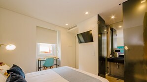 A modern hotel room with a bed, desk, chair, and a flat-screen TV. - BAIRRO ALTO MUSIC GUEST HOUSE BEETHOVEN (Lisboa ciudad)