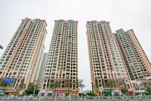 A high-rise residential building with multiple floors, balconies, and a gated entrance. - Kaisheng Express Hotel (Beihai)