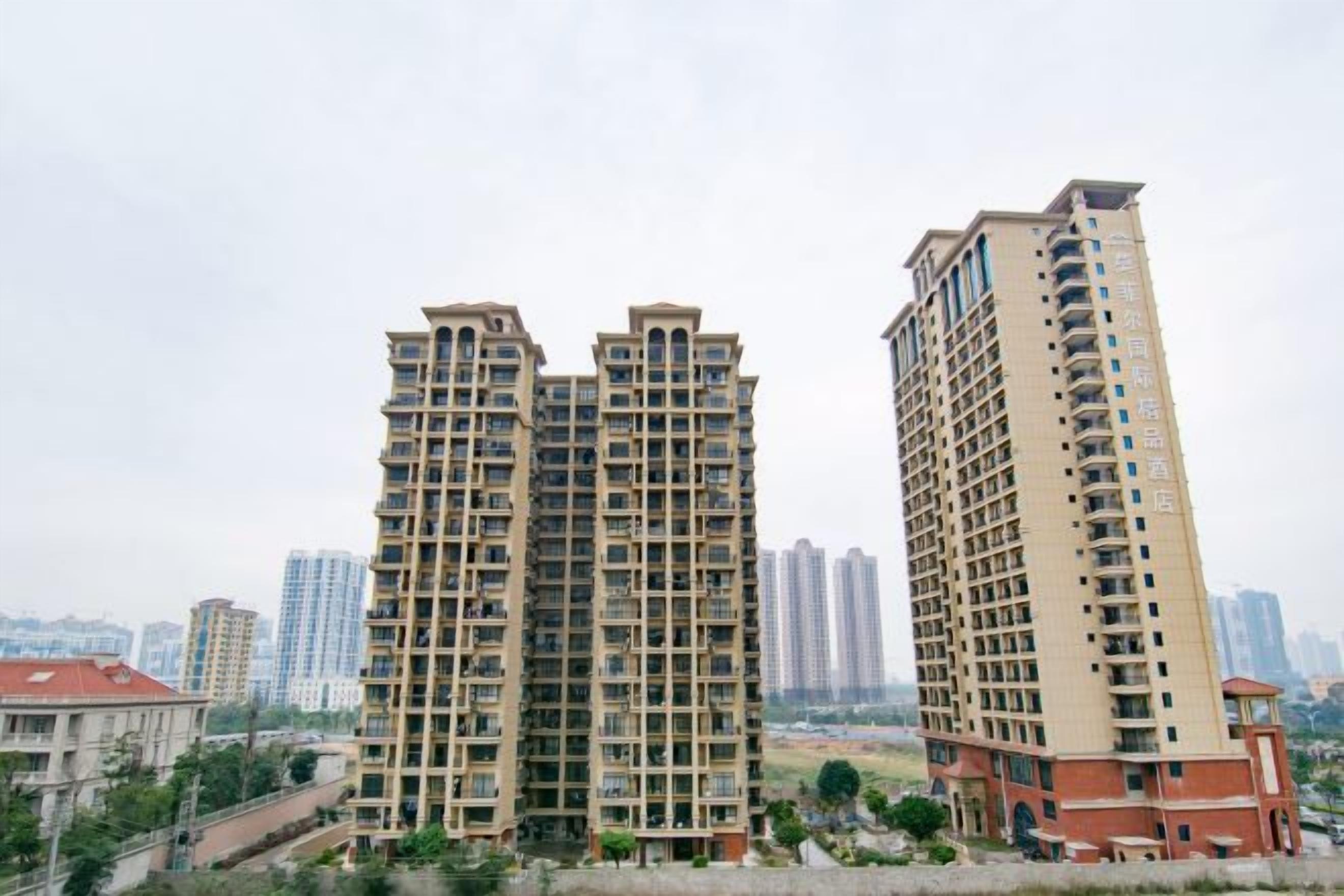 A high-rise residential building with multiple balconies, a flat roof, and a uniform facade.