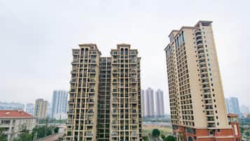 A high-rise residential building with multiple balconies, a flat roof, and a uniform facade.