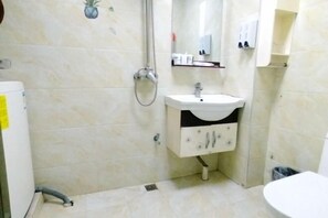 Ein Badezimmer mit einem weißen Waschbecken, einem Spiegel und einer Dusche.