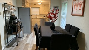 A dining area with a table set for four, a coffee station, and a kitchen in the background. - Clair de Lune, Lake Front on Lake Palestine  (Chandler)