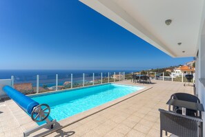 A rooftop pool with a clear view of the ocean, a barbecue area, and outdoor seating. - Villa ElDoMar (Calheta)