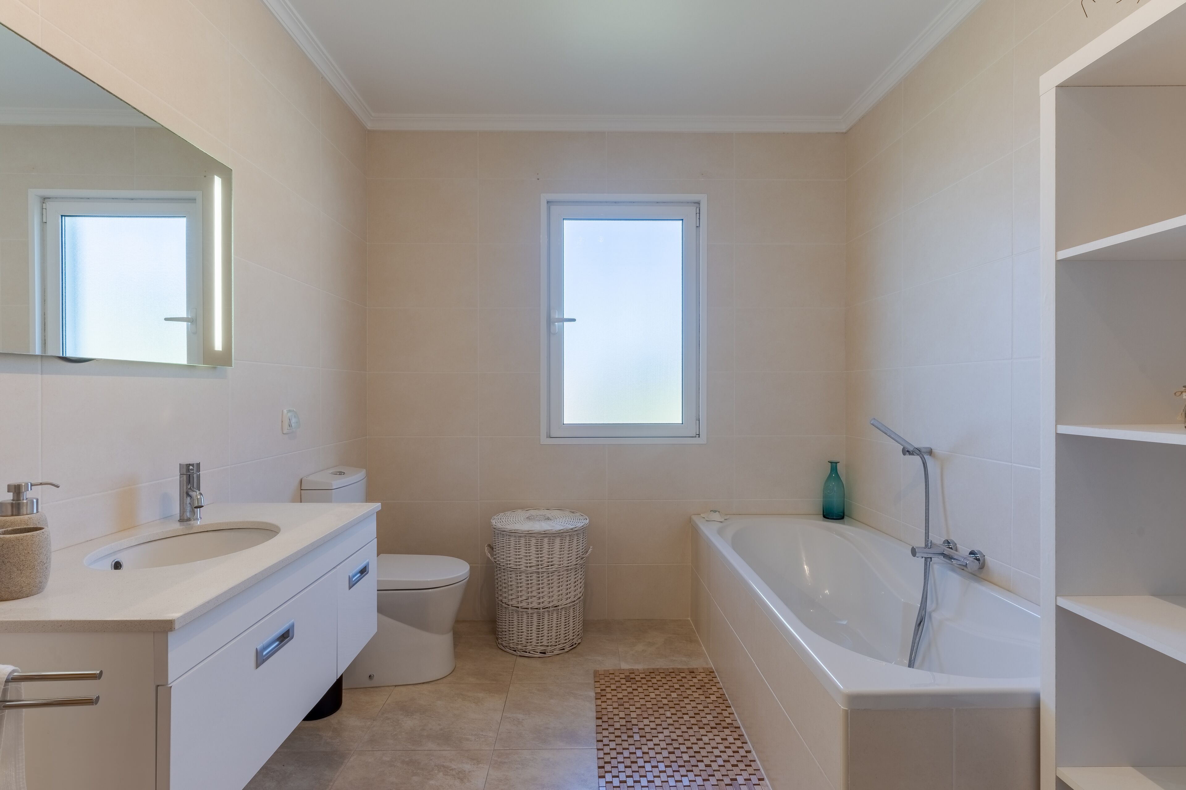 A modern bathroom with a sink, toilet, and bathtub.