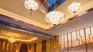 A hotel lobby with a high ceiling, large chandeliers, and a view of the sky through skylights. - Lanxin Hotel (Shaoxing)