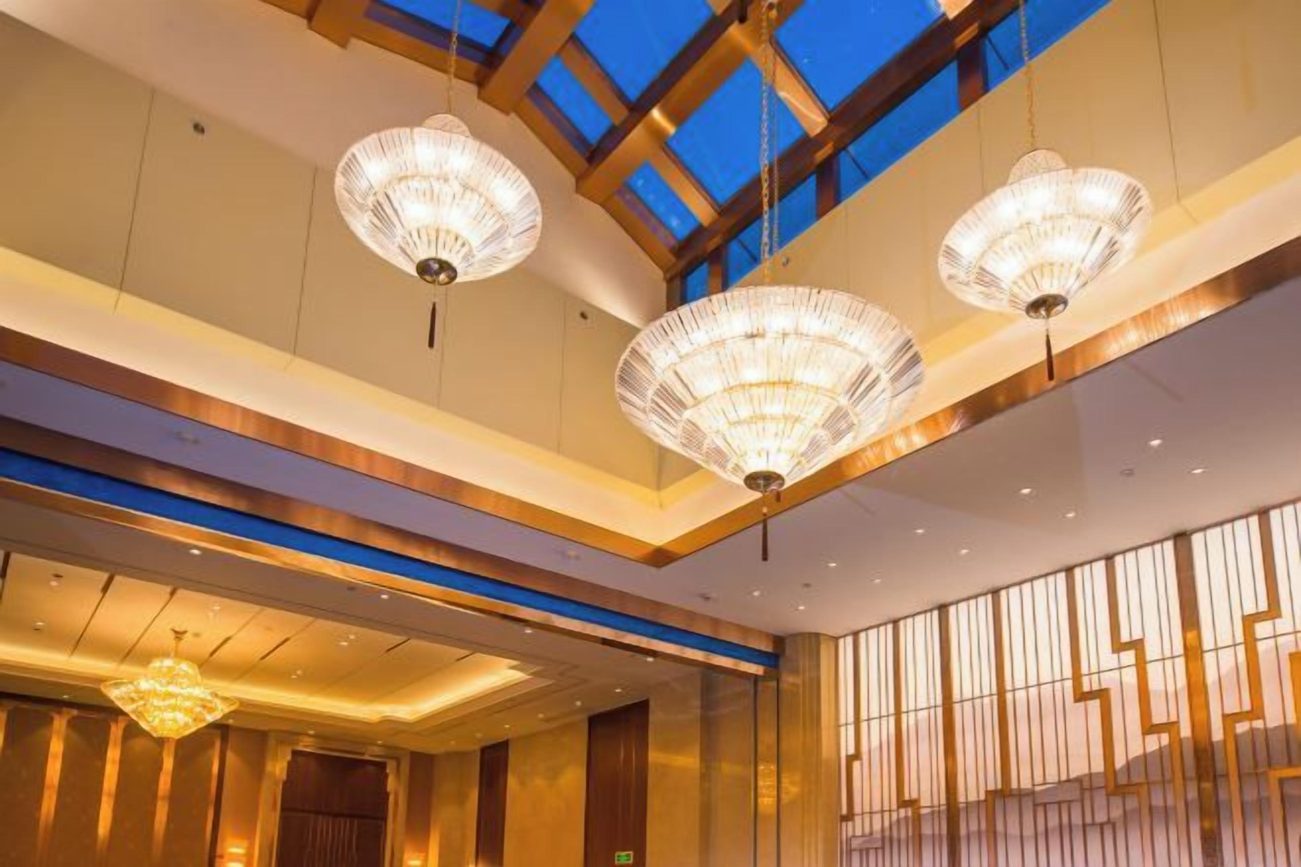 Un hall de hotel con candelabros, tragaluces y un diseño moderno.