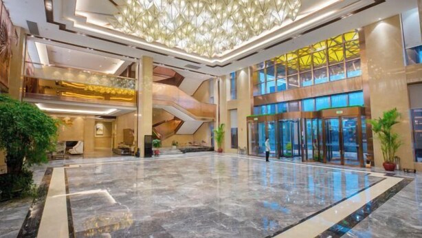 A spacious lobby with a high ceiling, a modern chandelier, and a glass elevator entrance. - Lanxin Hotel (Shaoxing)