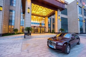 A luxury building with a grand entrance, a parked luxury car, and a well-maintained exterior. - Lanxin Hotel (Shaoxing)