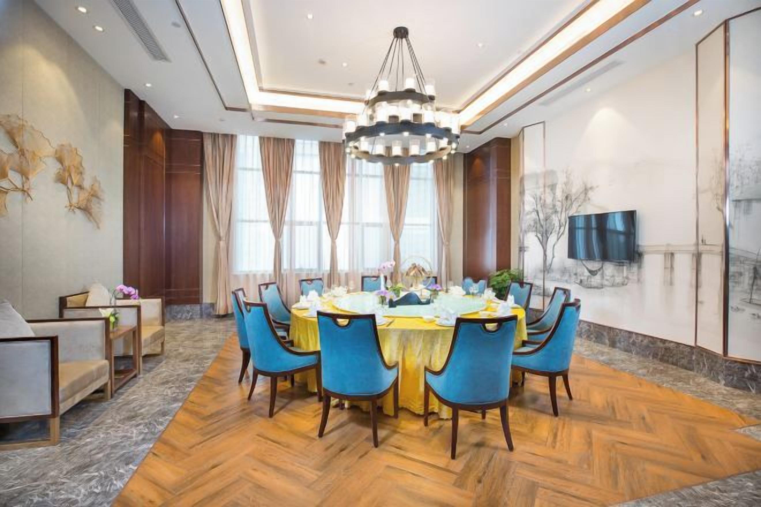 Un coin repas avec une table ronde, des chaises et un lustre.