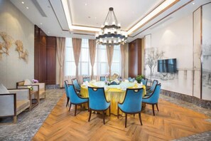 Un coin repas avec une table ronde, des chaises et un lustre.