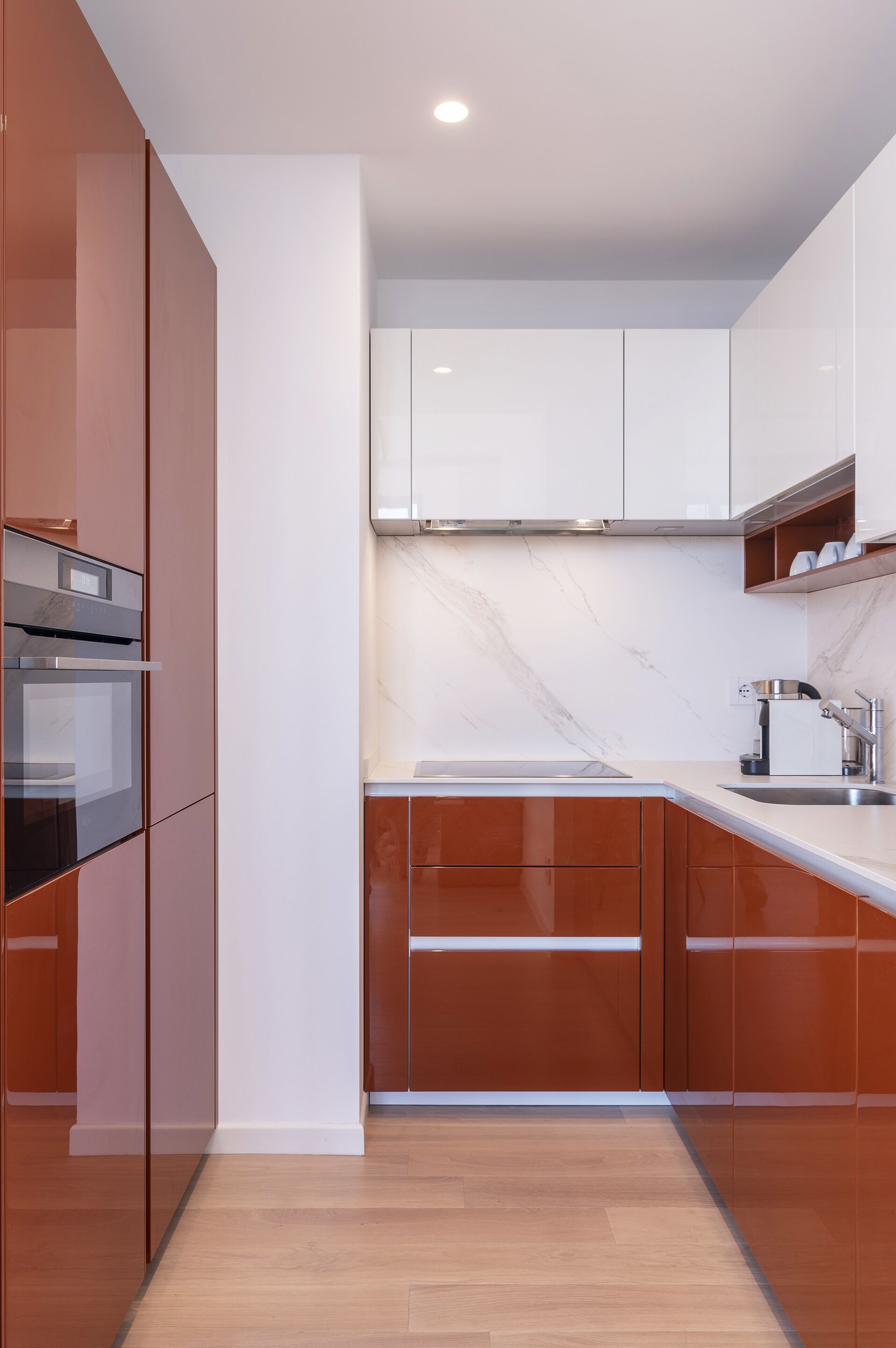 Una cocina moderna con armarios de madera, salpicadero de mármol y electrodomésticos de acero inoxidable.