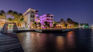 A waterfront hotel with a modern design, featuring balconies and a pool area. - Diamante Beachfront Suites (San Pedro)