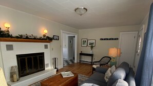 Un salon avec une cheminée, un canapé, une table basse et une lampe.