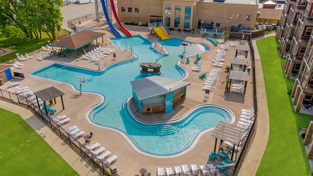Un área de piscina con múltiples toboganes y sillas reclinables.