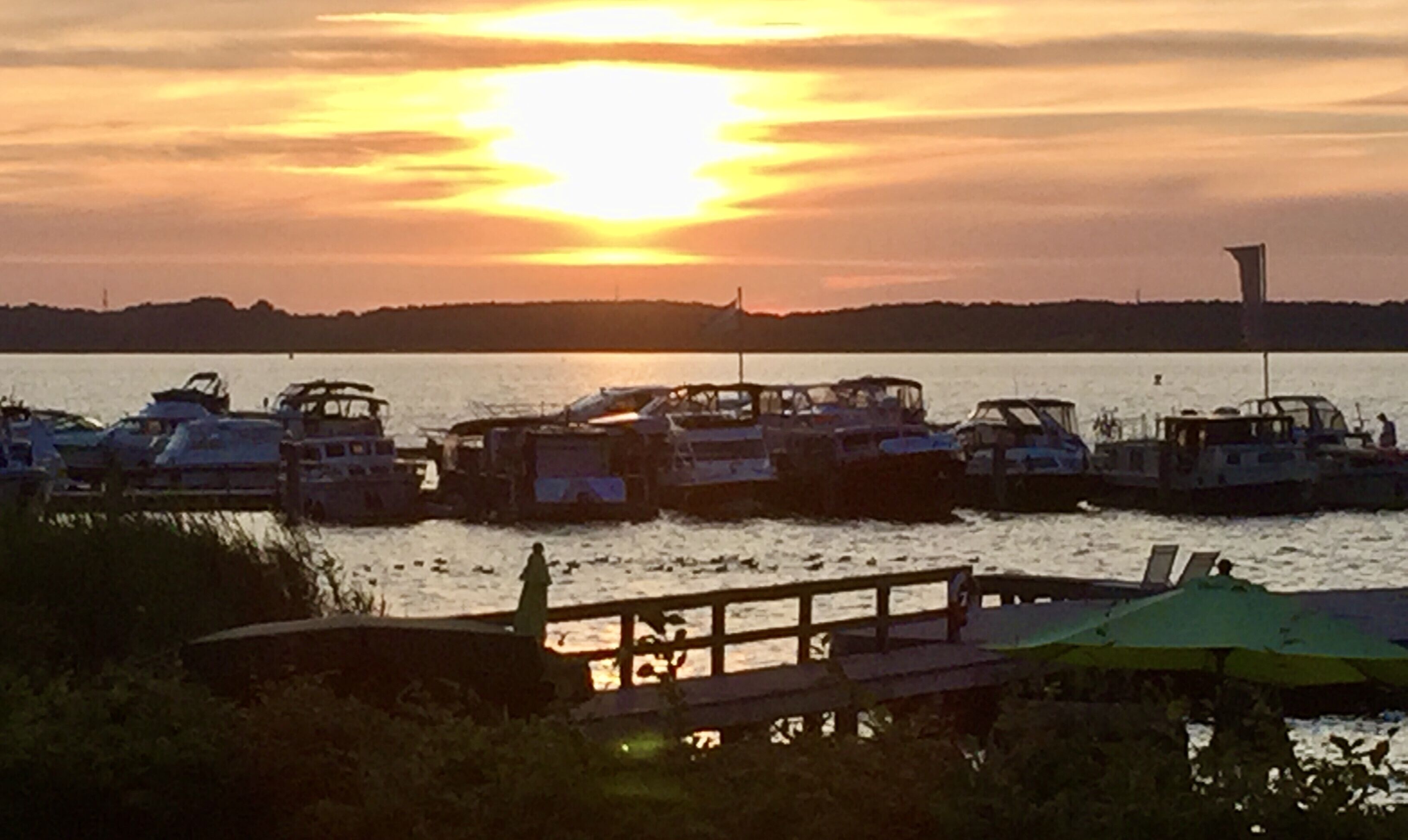 A marina with several boats docked at sunset.