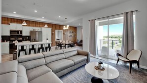 A modern living space with a sofa, dining area, kitchen, and a balcony with curtains. - 2 Bedrooms/ 2 Bathrooms/ Storey Lake (3191-405 PC) (Kissimmee)