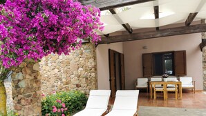 A stone wall with a wooden bench and a table with chairs in the center. - Suestellas, House quiet, relaxing, wifi, eco-friendly, surrounded by greenery (Teulada)
