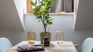 Une table à manger avec deux chaises, une plante en pot et deux verres.