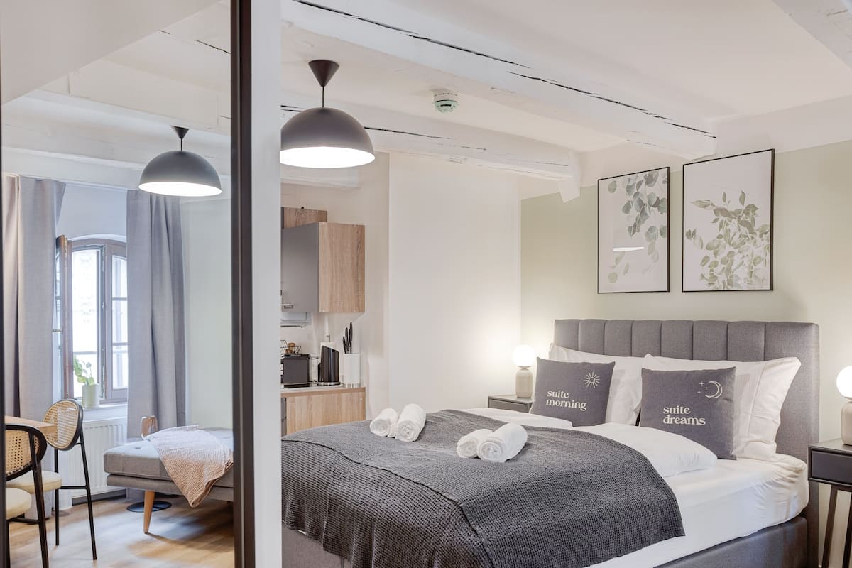Une chambre à coucher moderne avec un grand lit, deux tables de chevet, un bureau et une chaise.