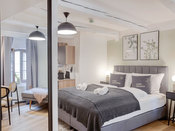 A modern bedroom with a large bed, two bedside tables, a desk, and a chair. - Limehome Zwickau Hauptmarkt (Zwickau)