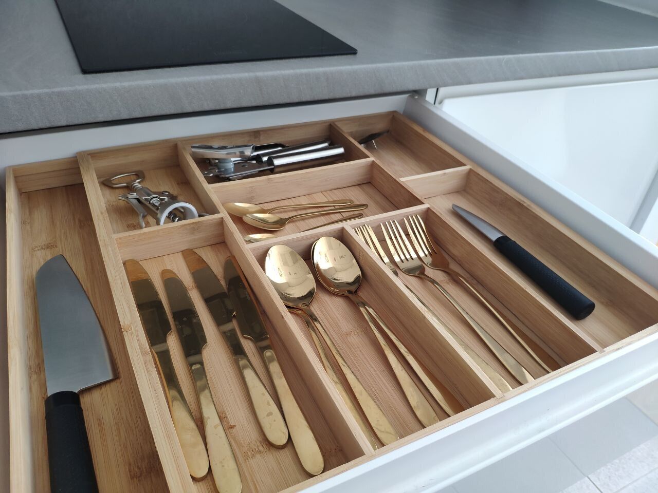 A kitchen drawer with utensils and cookware.