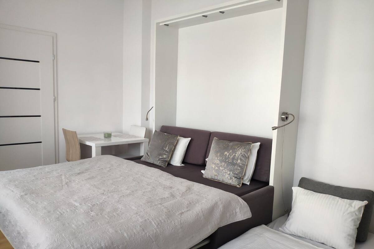 A bedroom with a bed, a desk, and a chair.