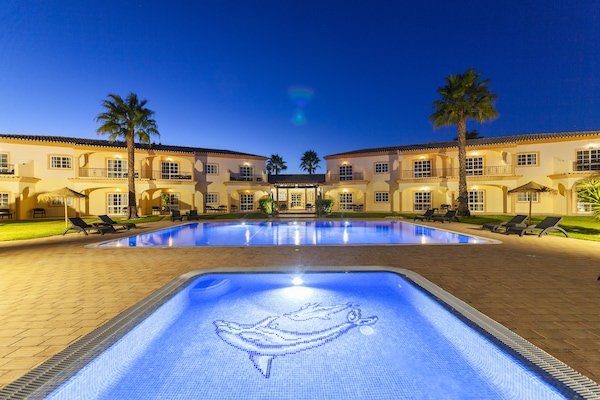 Een buitenzwembad, parasols voor strand/zwembad