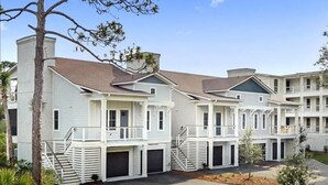 A row of white two-story townhouses with balconies, a central staircase, and a well-maintained lawn. - Escape to The Moorings #42 (Jekyll Island)