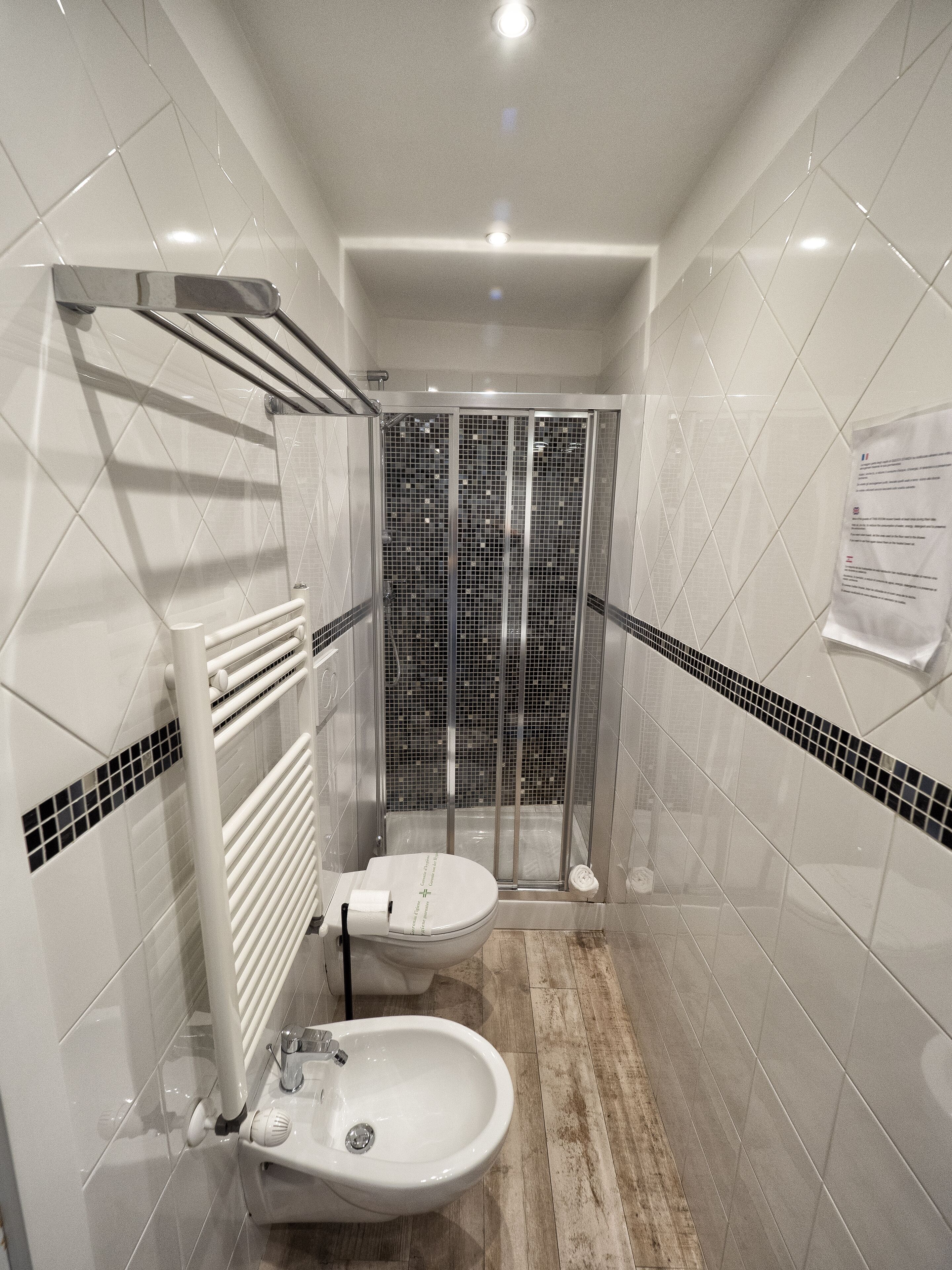 A modern bathroom with a shower, toilet, and bidet.