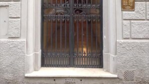 A building entrance with a metal gate, a small window, and a door. - BandBFirenze 8Cittadella8 (Florence)