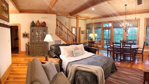 Ein geräumiges Zimmer mit einem großen Bett, einem Essbereich und einer Treppe, die zu einer weiteren Ebene führt.