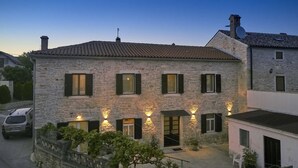 A stone building with multiple windows and a sign indicating directions to Pula/Pola and Sisan/Sissano. - Nice apartment for 2 people, 3 stars, 5 minutes to the beach (Ližnjan)