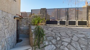A stone courtyard with a metal gate, a potted plant, and a stone wall. - Nice apartment for 2 people, 3 stars, 5 minutes to the beach (Ližnjan)