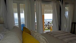 A bedroom with two beds, white bedding, and a view of the ocean through open curtains. - "Atlantique" is a seaside space to be remembered! (Lowlands)