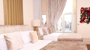 A hotel room with two beds, a large window with curtains, a mirror, and a floral wall decoration. - Signature Living Bold Street Apartments (Liverpool)