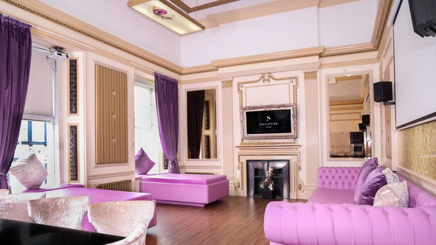 A luxurious living room with a fireplace, a television, and plush seating. - Signature Living Bold Street Apartments (Liverpool)