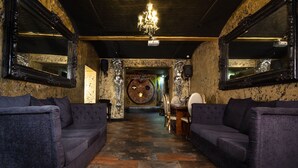 A lobby with dark wood flooring, two sofas, a chandelier, and ornate wall decorations. - Signature Living Bold Street Apartments (Liverpool)