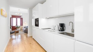 A modern kitchen with white cabinets, a built-in oven, a coffee maker, and a sink. - Zabalza- Holiday rental in Malaga (Málaga)