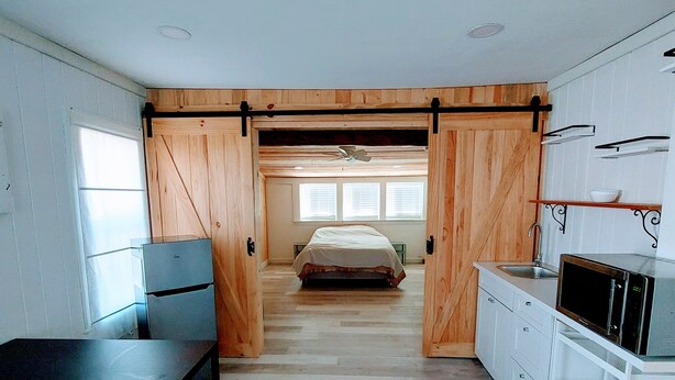 A compact bedroom with a bed, a desk, and a kitchenette. - **Minimalist Mtn Living- Pets Welcome (30+ Days)** (Fairplay)
