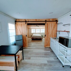 A compact bedroom with a bed, a desk, and a kitchenette. - **Minimalist Mtn Living- Pets Welcome (30+ Days)** (Fairplay)